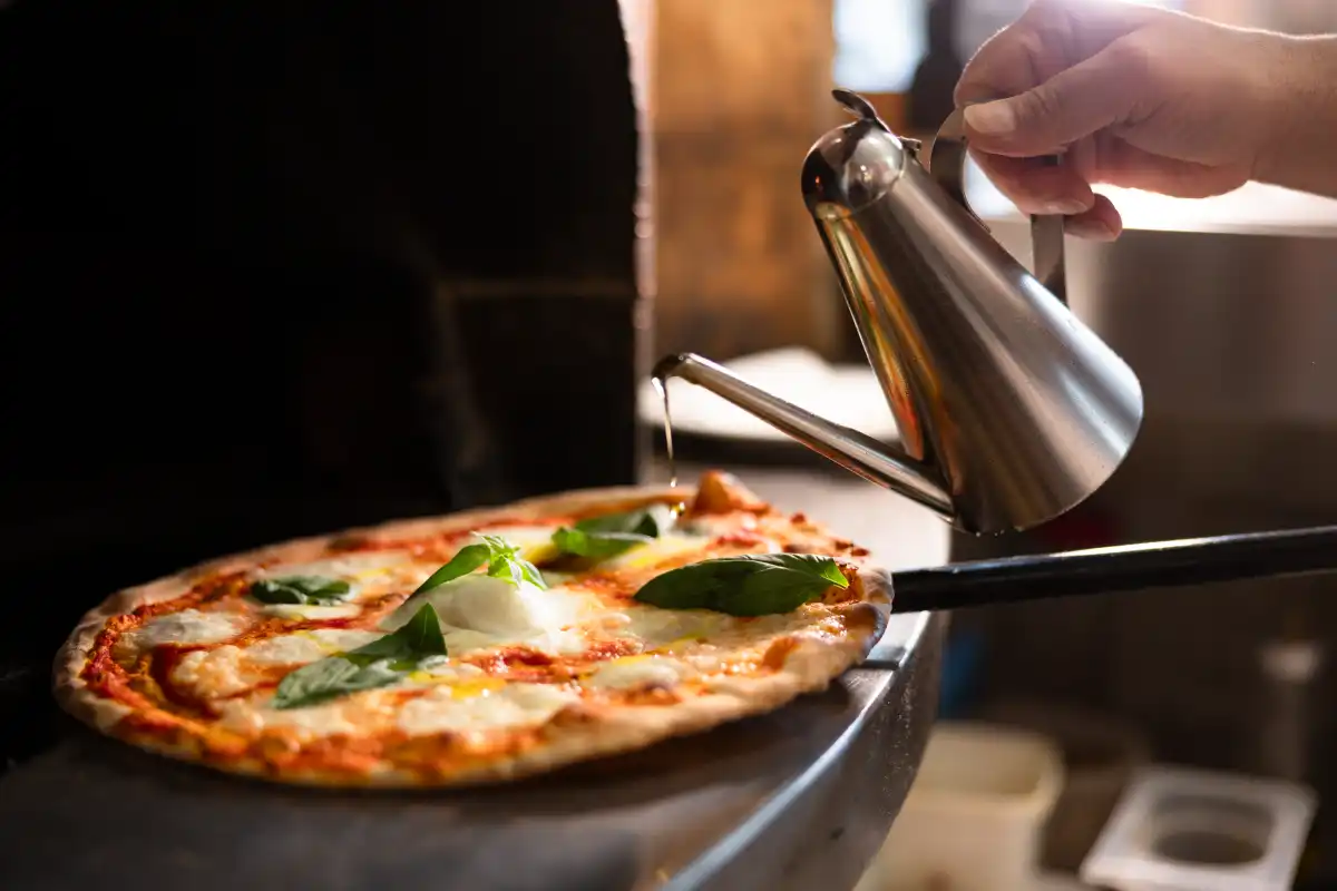 Il forno a legna di Ristorante TRE durante la preparazione di una pizza